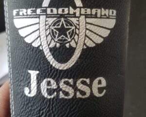 Custom laser engraved black leatherette tumbler sleeve with logo and name Jesse by Pro Laser Graphics
