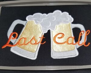 Custom embroidered "Last Call" beer mugs design on dark fabric by Pro Laser Graphics