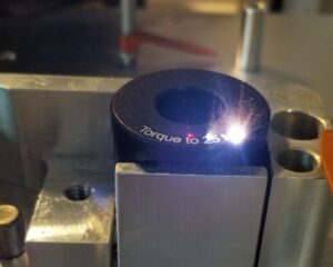 Precision laser marking machine etching small industrial metal component in action